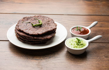 Ragi roti or flat Bread made using finger millet is a healthy and tasty breakfast dish of Karnataka, India. served with green chilli and chutney. selective focus