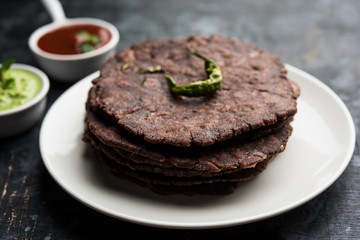 Fototapeta na wymiar Ragi roti or flat Bread made using finger millet is a healthy and tasty breakfast dish of Karnataka, India. served with green chilli and chutney. selective focus