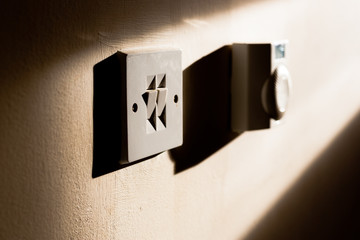 Sunlight shines on a light switch and thermostat in home in England