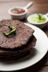 Ragi roti or flat Bread made using finger millet is a healthy and tasty breakfast dish of Karnataka, India. served with green chilli and chutney. selective focus