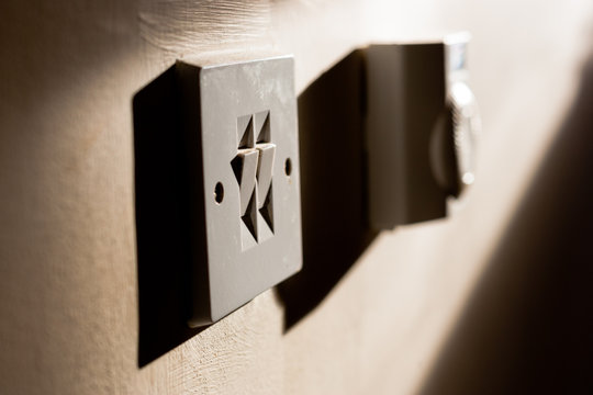 Sunlight shines on a light switch and thermostat in home in England
