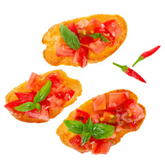 top view of tasty chopped tomato on slices of toasted baguette garnished with basil, salt and peppers, Italian appetizers bruschetta, isolated on white background