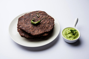Ragi roti or flat Bread made using finger millet is a healthy and tasty breakfast dish of Karnataka, India. served with green chilli and chutney. selective focus