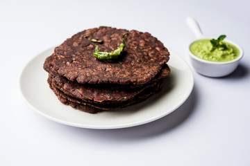 Ragi roti or flat Bread made using finger millet is a healthy and tasty breakfast dish of Karnataka, India. served with green chilli and chutney. selective focus