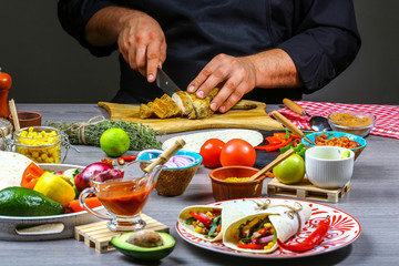 Close up of a chef hands cuts meat for mexican burito. Cook preparing delicious mexican burito at kitchen. border Mexican cuisine
