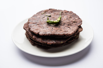Fototapeta na wymiar Ragi roti or flat Bread made using finger millet is a healthy and tasty breakfast dish of Karnataka, India. served with green chilli and chutney. selective focus