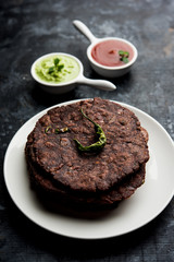 Ragi roti or flat Bread made using finger millet is a healthy and tasty breakfast dish of Karnataka, India. served with green chilli and chutney. selective focus