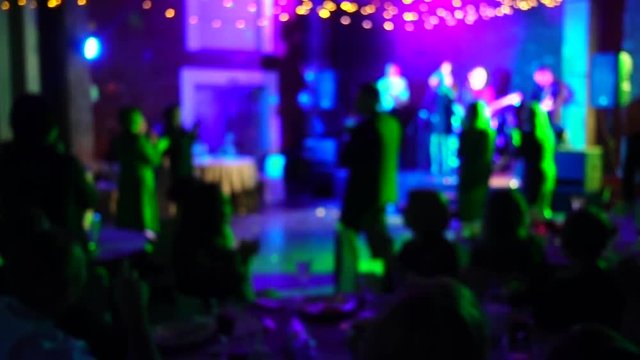 Defocused image of dancing people in a nightclub or restaurant.