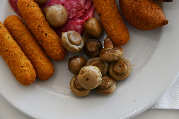 Potato balls and Fried mushrooms on plate