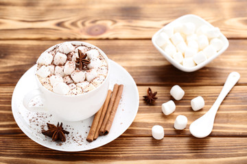 Obraz na płótnie Canvas Cappuccino with marshmallows, cinnamon and star anise on wooden table