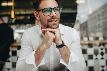Smiling man sitting relaxed in a cafe