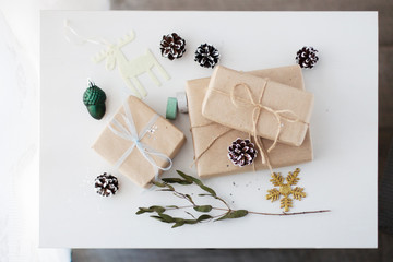 Christmas composition: gift boxes, cones and Christmas decorations on a white wooden table