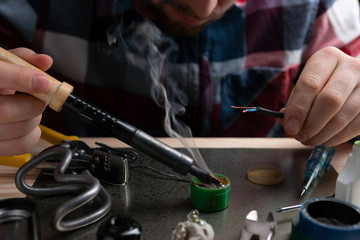 Man soldering wires with tin
