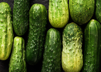Cucumbers pattern on black background. Healthy food, top view, flat lay, copy space
