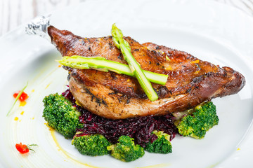 Grilled pork chop steak on the bone with asparagus and broccoli on light wooden background close up. Hot Meat Dishes. Top view