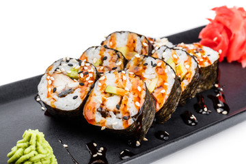Sushi Roll - Maki Sushi made of smoked eel, Crab meat, avocado on black plate isolated over white background. Japanese cuisine