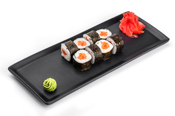 Sushi Roll - Maki Sushi with salmon and cream cheese on black plate isolated over white background. Japanese cuisine