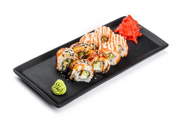 Sushi Roll - Maki Sushi made of salmon, smoked eel, cucumber, avocado and cream cheese on black plate isolated over white background. Japanese cuisine
