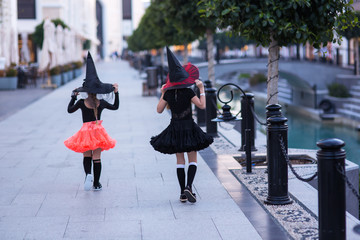 Two running girls fairies in carnival costumes. Back view.