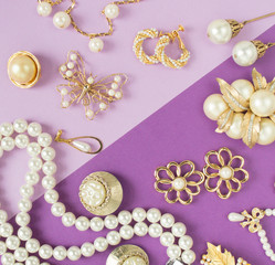 Woman's Jewelry. Vintage jewelry background. Beautiful gold tone and pearls brooches, braceletes,...