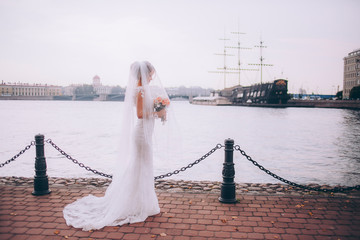 Obraz premium Portrait of a beautiful bride in a white wedding dress and bouquet