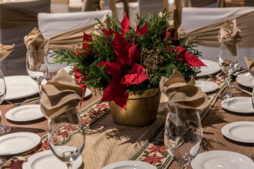 mesa navideña, con nochebuena, copas y manteles de fiesta