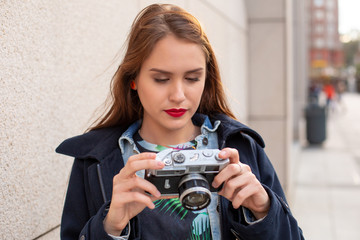 Portrait of a pretty young tourist taking photographs with vintage retro camera