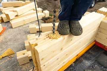Drilling holes in laminated veneer lumber for shkantov. Construction of the house from the profiled glued bar.