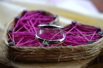 wedding rings lie on the background of the red heart of love