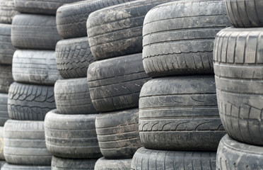 Obraz premium Used wheel tires stacked ready for recycling.