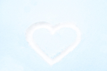 Blue heart shape drawing on white snow as love valentine background