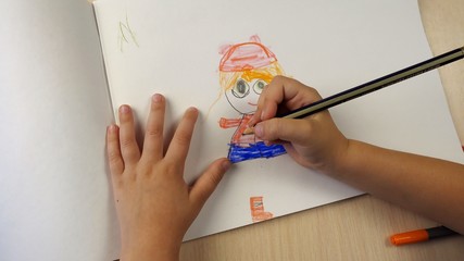The point of view of the child, who paints with colored pencils.