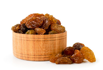 Raisins in a wooden bowl closeup on a white background.