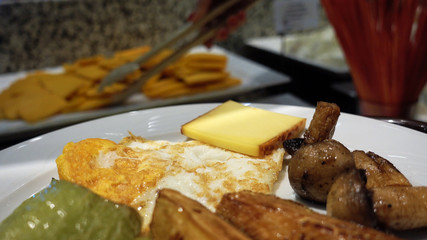 Point of view. Breakfast in the restaurant buffet. The person carries a tray with a plate on which lies pepper, mushrooms, scrambled eggs. Appetizing breakfast. The concept of eating healthy food.
