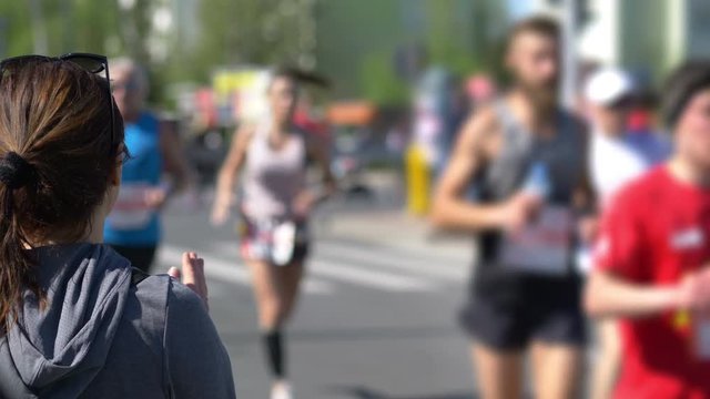 Woman cheering runners and clapping hands in 4k slow motion 60fps