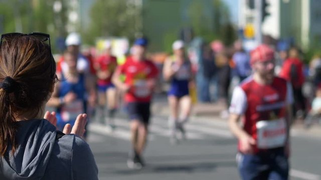 Woman cheering runners and clapping hands in 4k slow motion 60fps