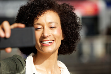 Close up smiling african american woman taking selfie with smart phone