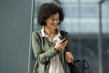 smiling african american woman looking at cellphone