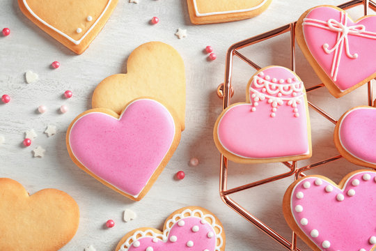 Flat lay composition with decorated heart shaped cookies on table