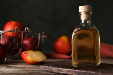 Composition with bottle of apple vinegar on table. Space for text