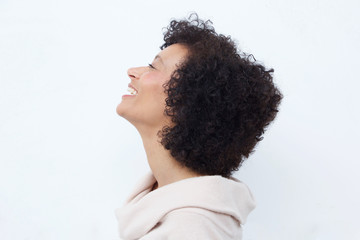 Profile portrait of woman laughing against white background