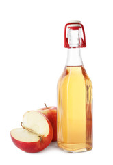 Glass bottle of vinegar and fresh apples on white background