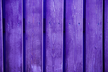The texture of a wooden fence with vertical ultraviolet boards, background