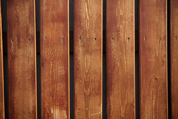 The texture of a wooden fence with vertical brown boards, background