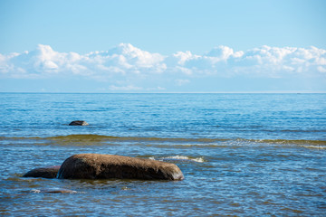 rock covered beach in countryside in Latvia, large rocks in water