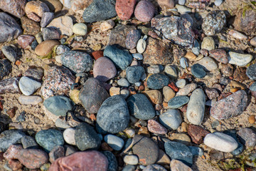rock covered beach in countryside in Latvia, large rocks in water