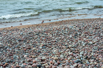 rock covered beach in countryside in Latvia, large rocks in water