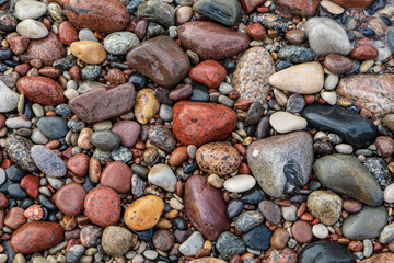 rock covered beach in countryside in Latvia, large rocks in water