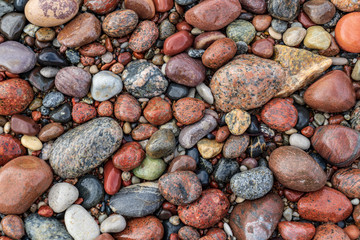 rock covered beach in countryside in Latvia, large rocks in water