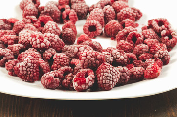 frozen berries used on a dish/frozen raspberry on a white dish, selective focus